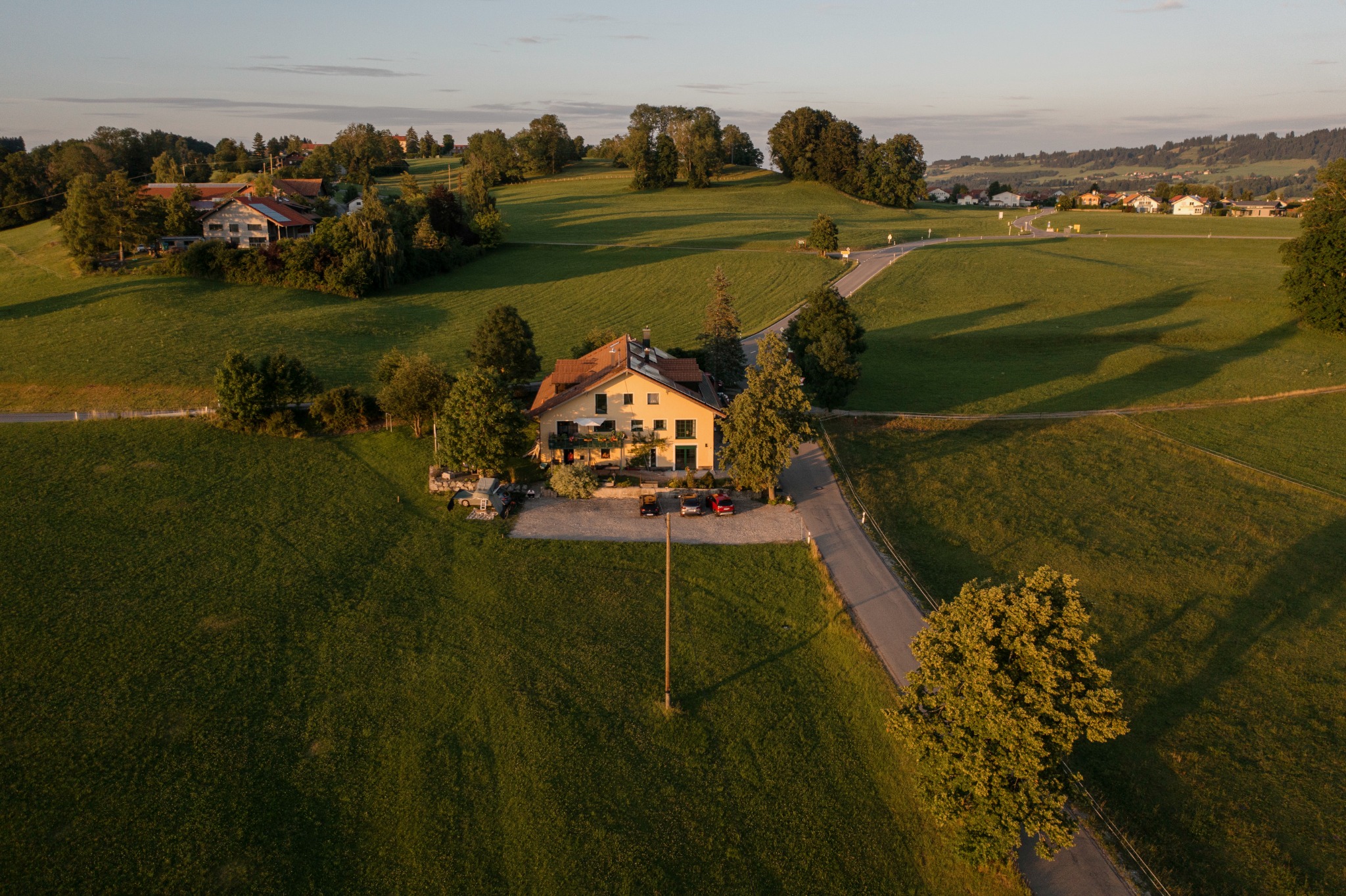 Das Haus Albis in der warmen Abendsonne, umgeben von Allgäuer Wiesen