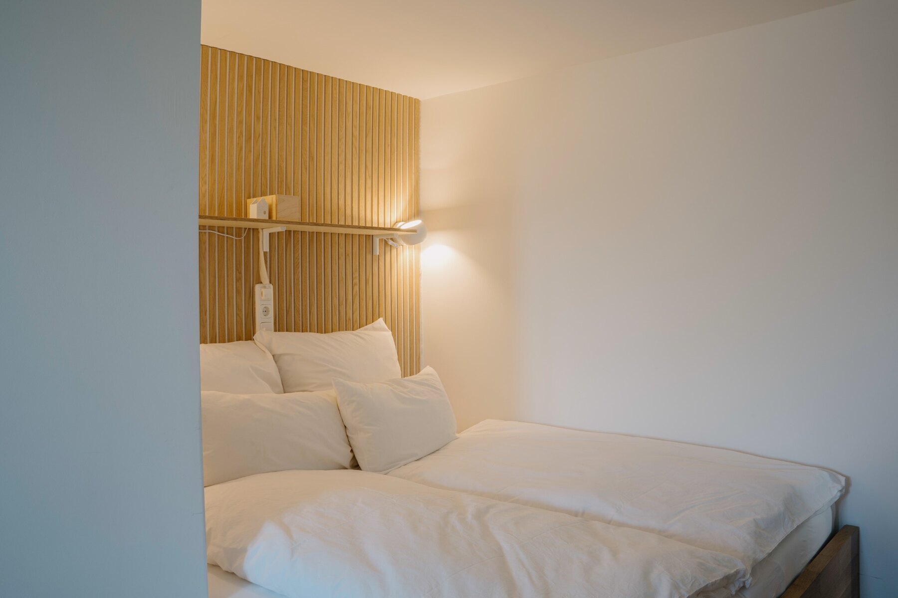 Schlafzimmer in Albis mit Doppelbett und Holzelementen